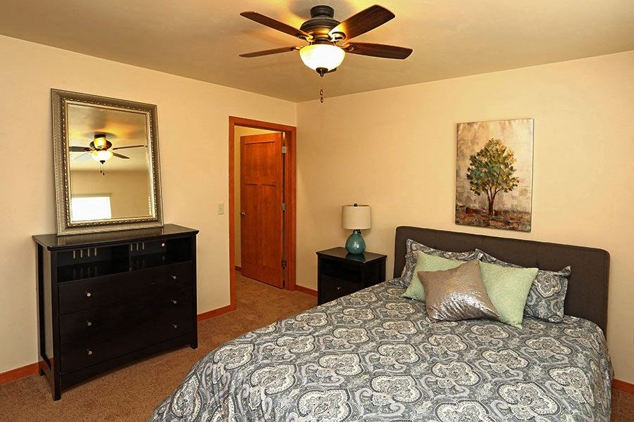 a bedroom with a bed and a ceiling fan