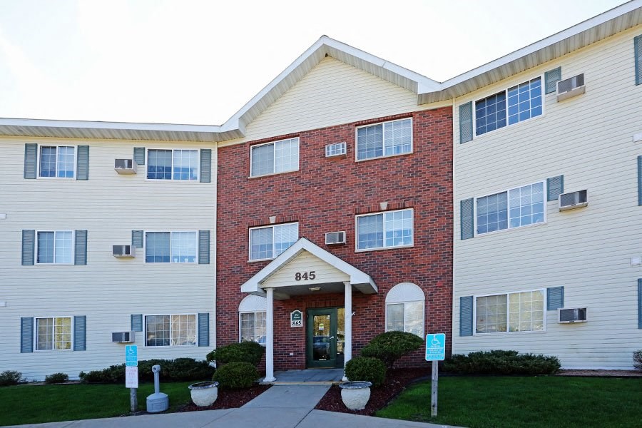 a brick and white building with a walkway in front of it