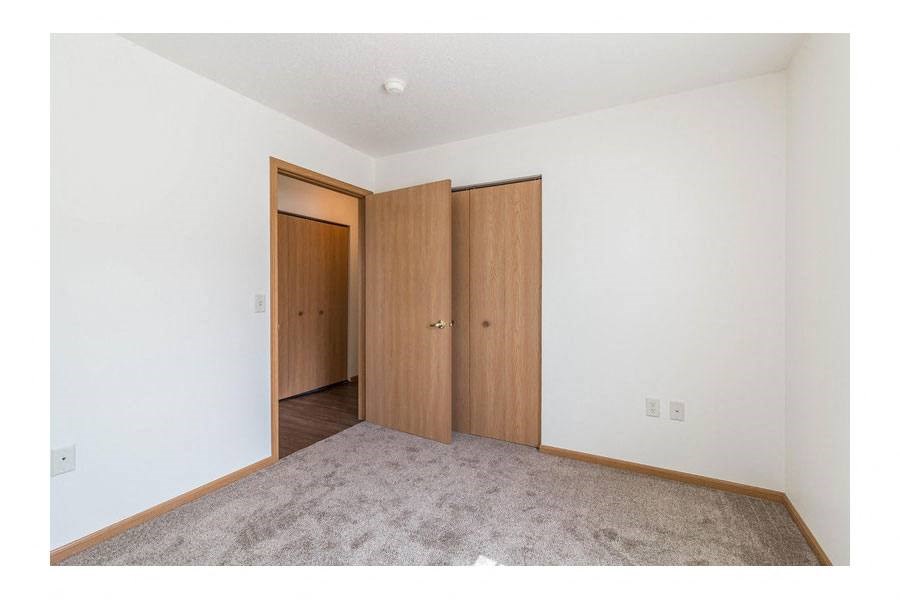 an empty room with a door to a closet