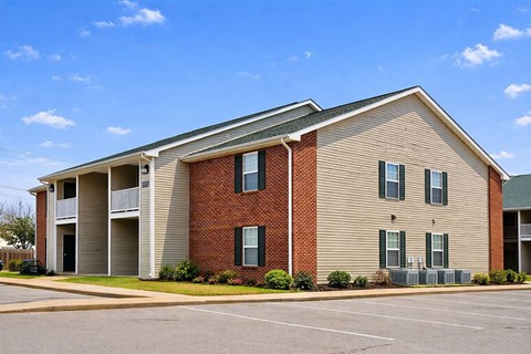 A large apartment building with a parking lot in front.