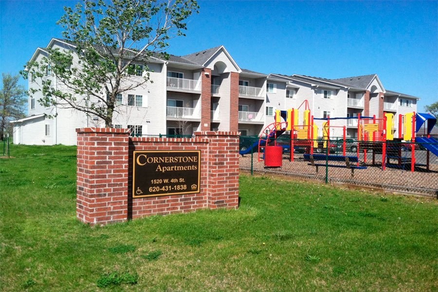 an apartment building with a playground and a sign