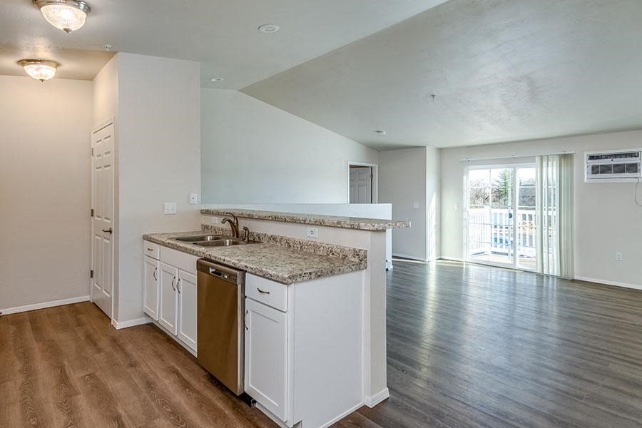 an empty kitchen with a sink and a counter top
