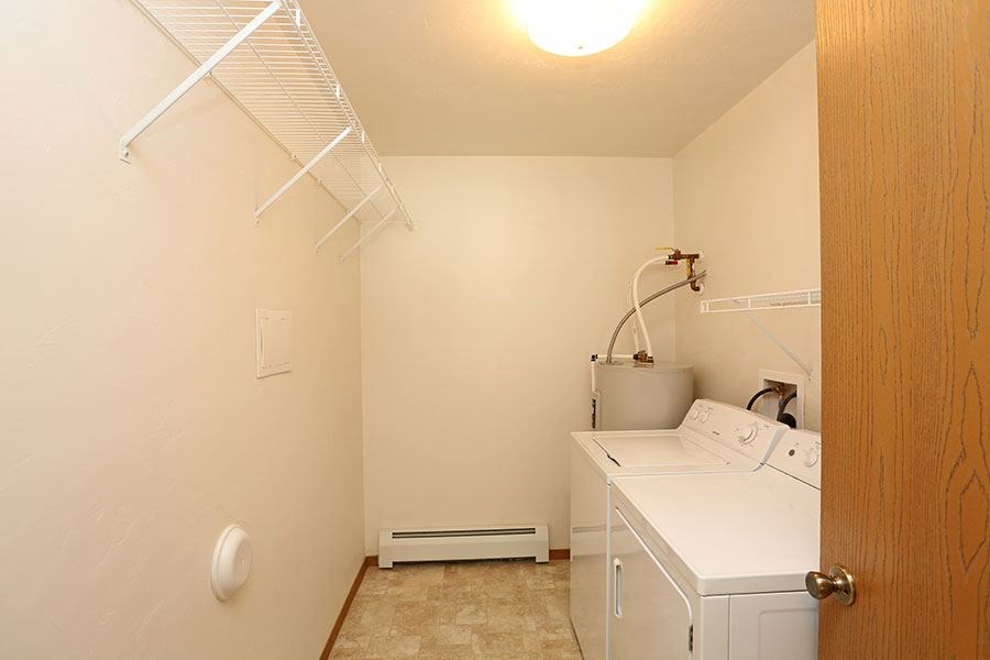 a small laundry room with a dryer and a sink