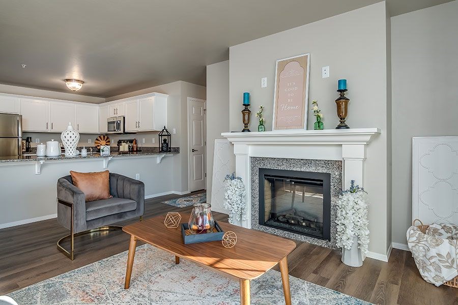 A living room with a fireplace and a grey couch.