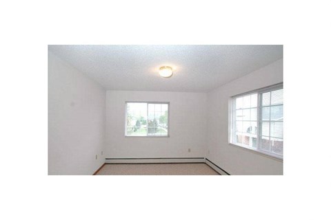 an empty room with a window and a lamp on the ceiling