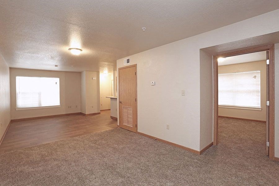 an empty living room with a door and a window