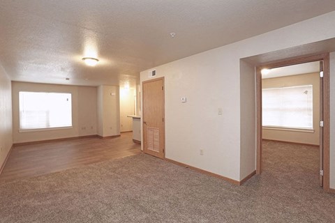 an empty living room with a door and a window