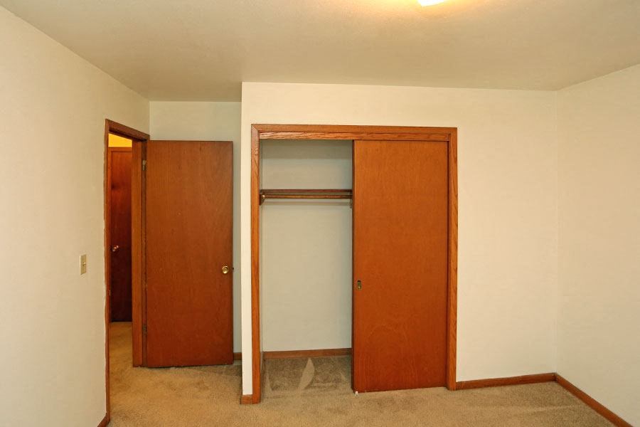 an empty room with a closet and a door