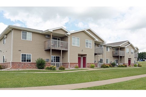 an apartment building with two stories and a red door
