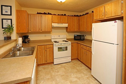 a kitchen with white appliances and wooden cabinets