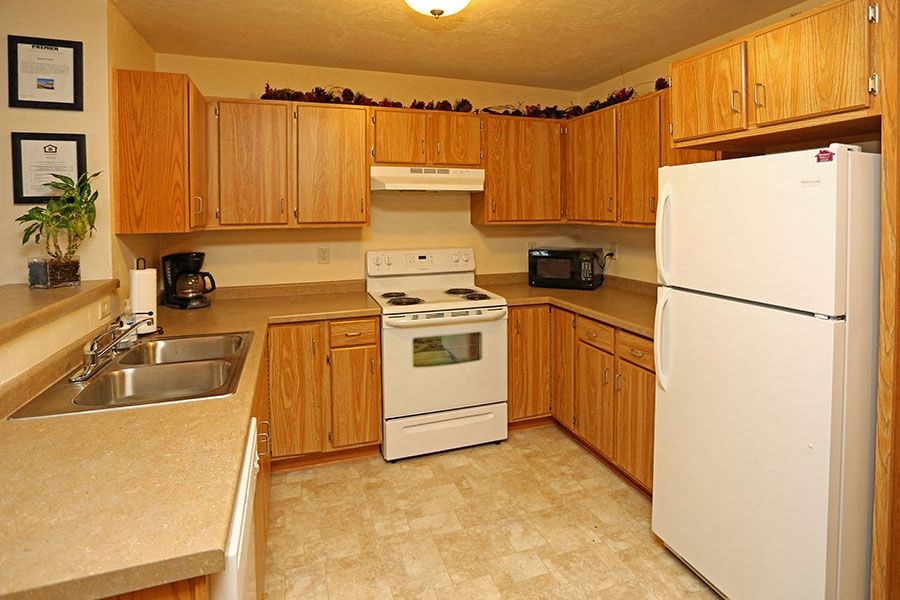 a kitchen with white appliances and wooden cabinets