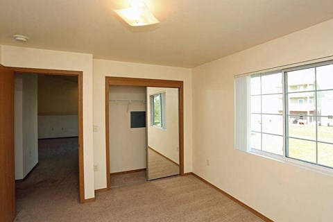 an empty living room with two doors and a window