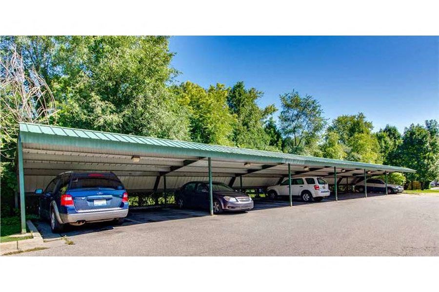 a parking lot with cars under a green roof