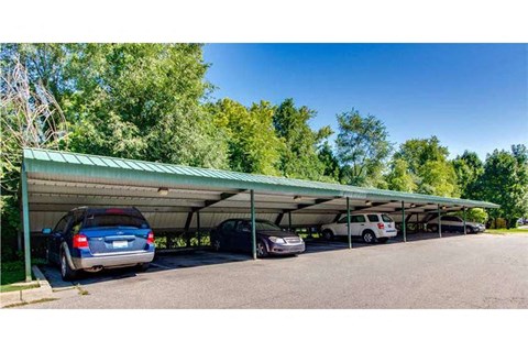 a parking lot with cars under a green roof