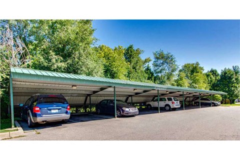 a parking lot with cars under a green roof