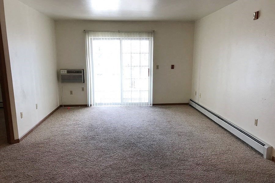 an empty room with a window and a carpet