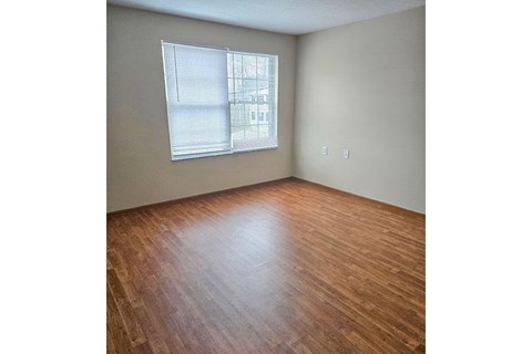Empty room with wooden floor and a window.