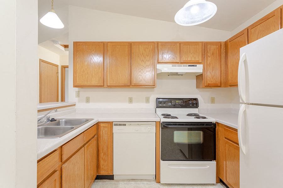 a kitchen with white appliances and wooden cabinets