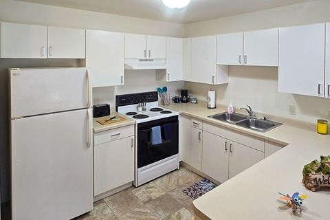A kitchen with white appliances and cabinets.