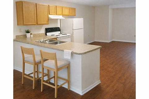 A kitchen with wooden chairs and a white counter.
