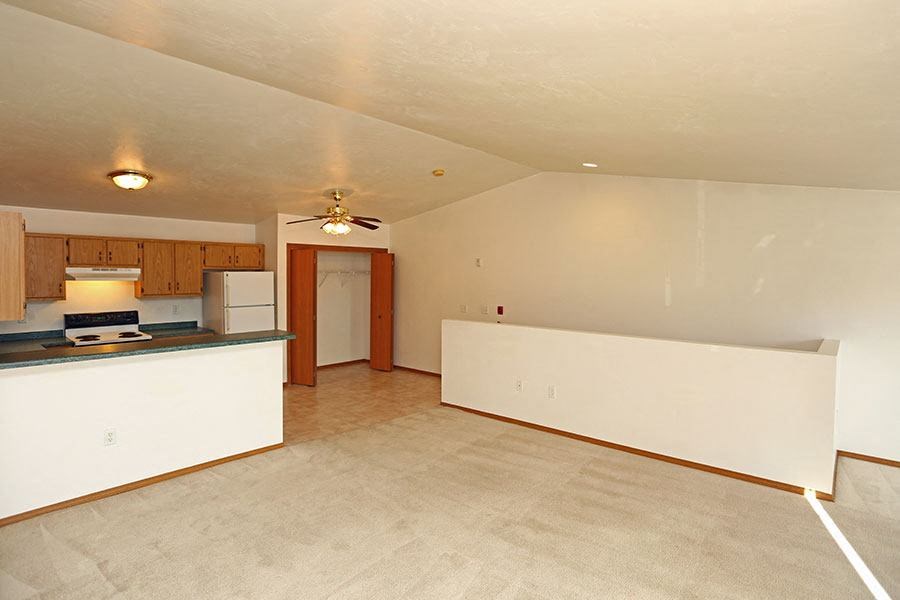 an empty living room and kitchen with a white floor
