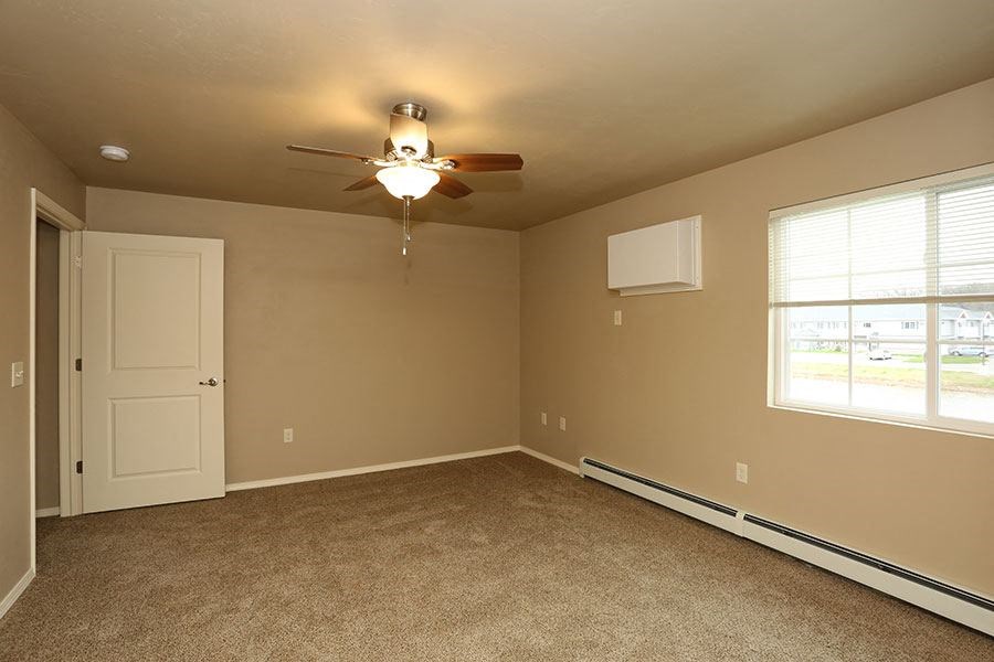 an empty room with a ceiling fan and a door