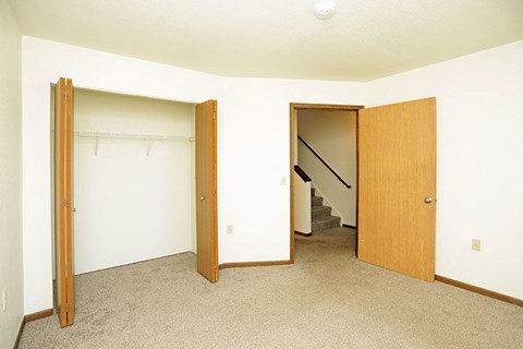 an empty room with two doors and a staircase