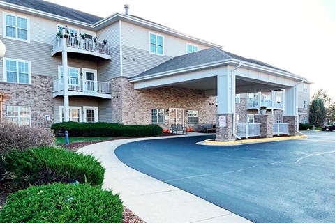 a building with a covered porch and a driveway