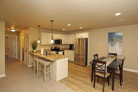 A kitchen with a table and chairs in front of it.