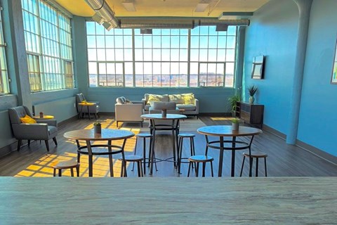 A room with a table and chairs in the foreground and a window in the background.