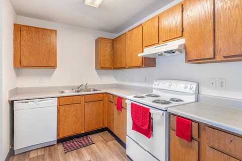 A kitchen with wooden cabinets and a white stove top oven.