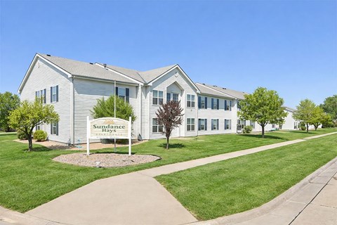 A white building with a sign that says Sundance Hays in front of it.