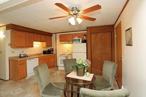 A kitchen with a table and chairs in the middle of the room.