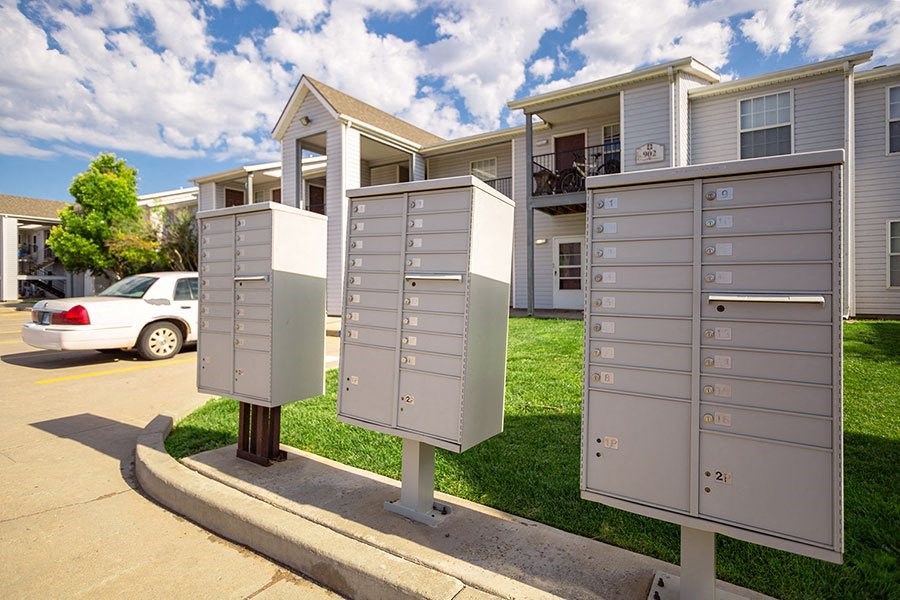 A row of mailboxes in front of apartment buildings.