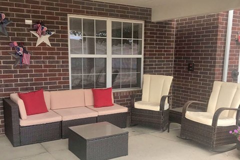 A patio with a couch, chairs, and a table.