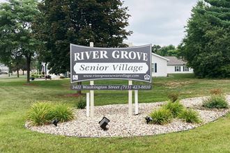 a sign for river grove senior village in the middle of a field
