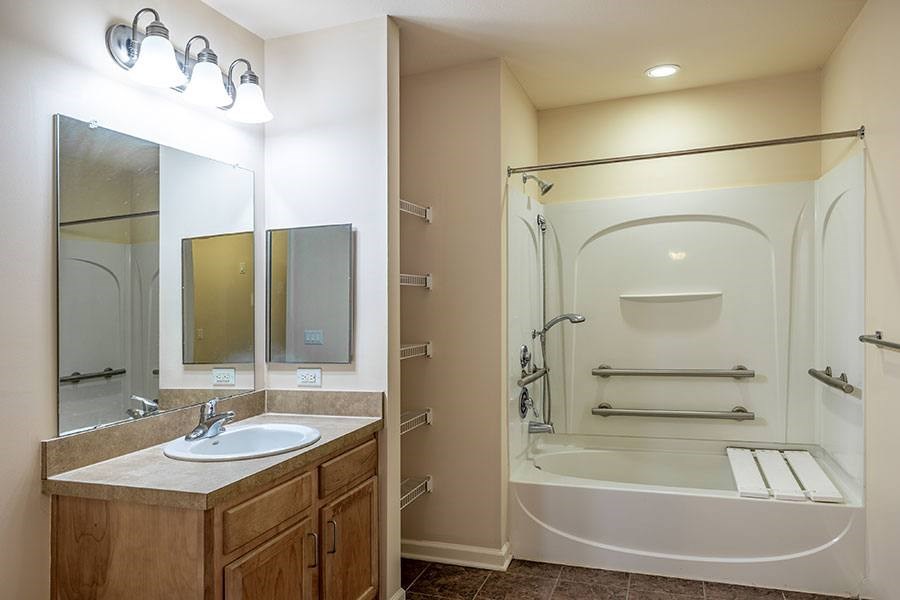 A bathroom with a sink, mirror, and shower.