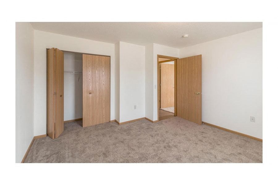 a bedroom with two doors and a carpet floor