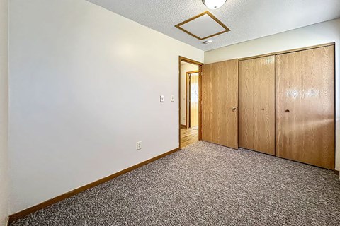 A room with a carpeted floor and a wall-mounted light fixture.