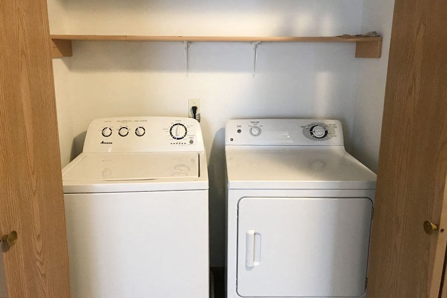 a kitchen with two white appliances and a cabinet