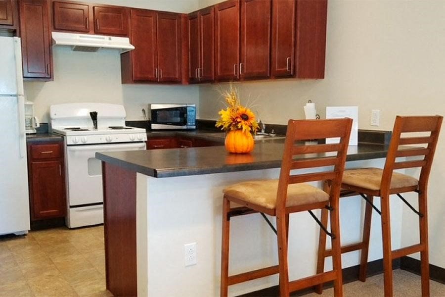a kitchen with a counter and two chairs