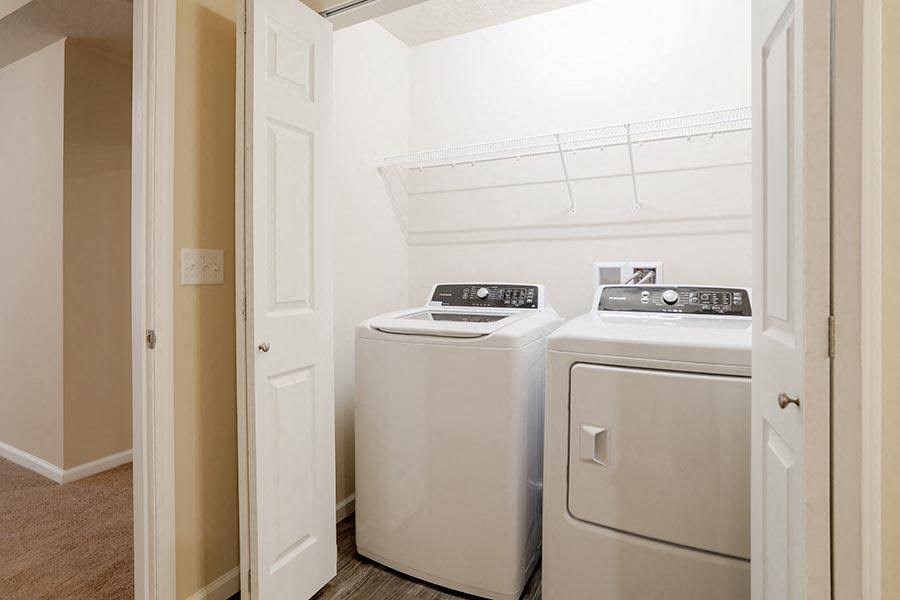 a white laundry room with two white appliances