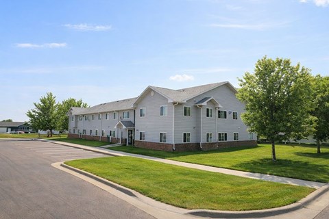 A large white building with a parking lot in front.