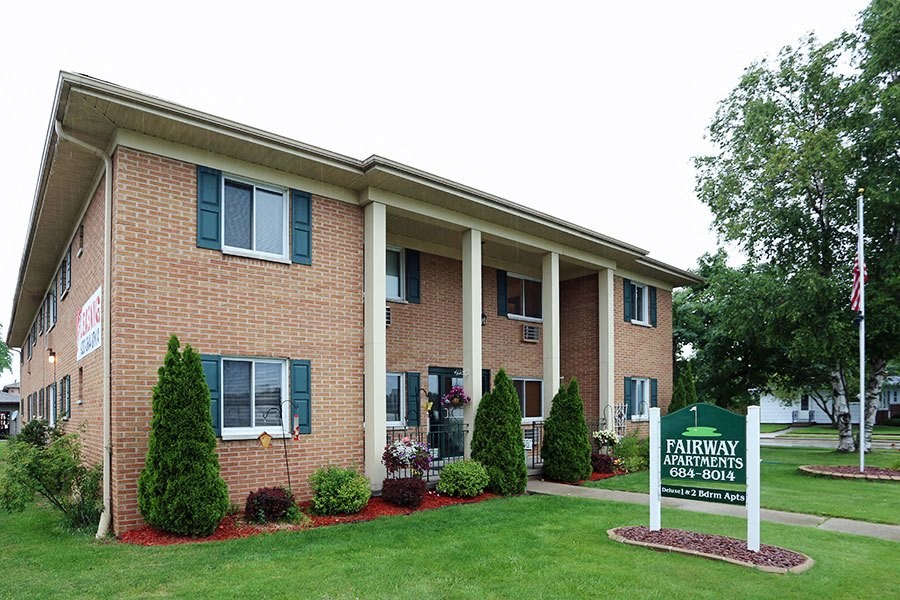 a brick building with a sign in front of it