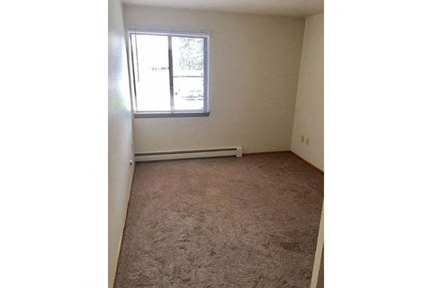an empty room with a window and a carpet