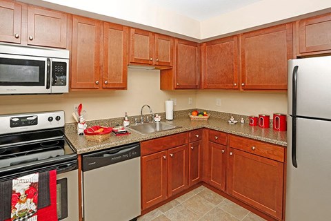 a kitchen with wooden cabinets and stainless steel appliances