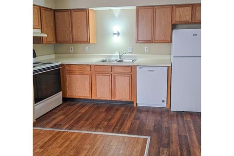 A kitchen with wooden cabinets and a white refrigerator.