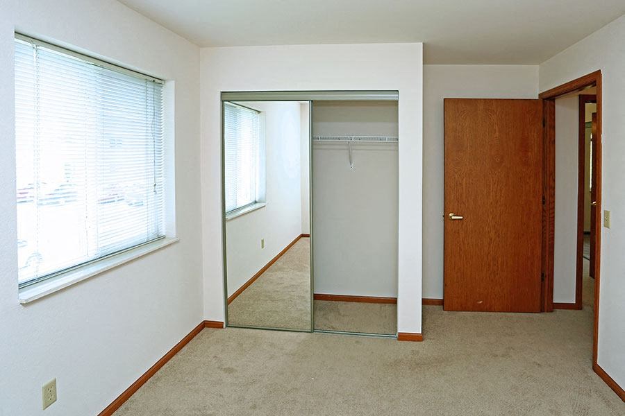 an empty room with a mirror and a closet