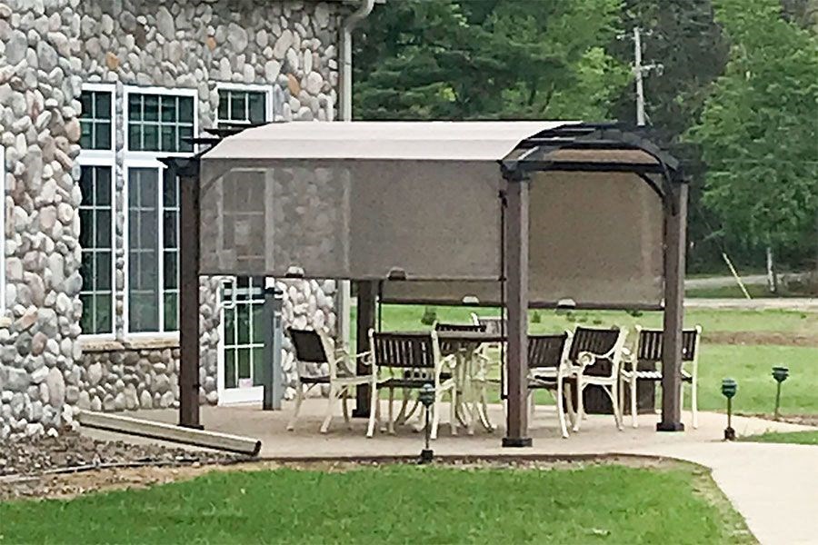 a patio with a table and chairs under a canopy