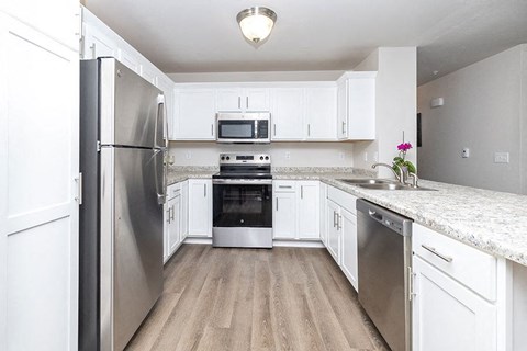 a kitchen with white cabinets and stainless steel appliances